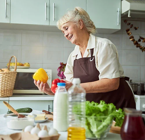 Dame âgée dans la cuisine, insouciante grâce à Senior Protection